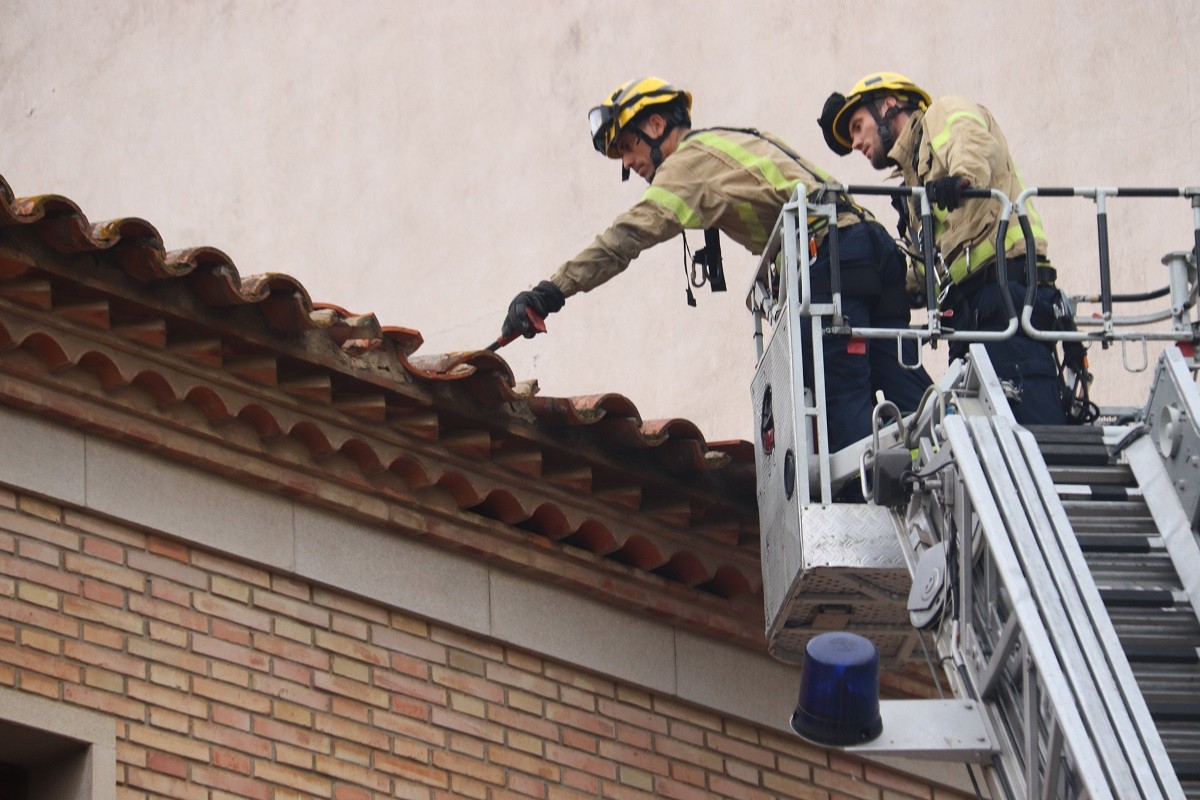 Els Bombers inspeccionant una teulada malmesa pel temporal