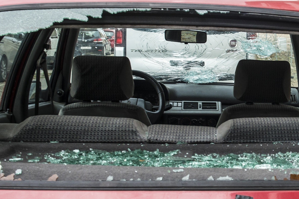Un cotxe amb el vidre destrossat per la pedra