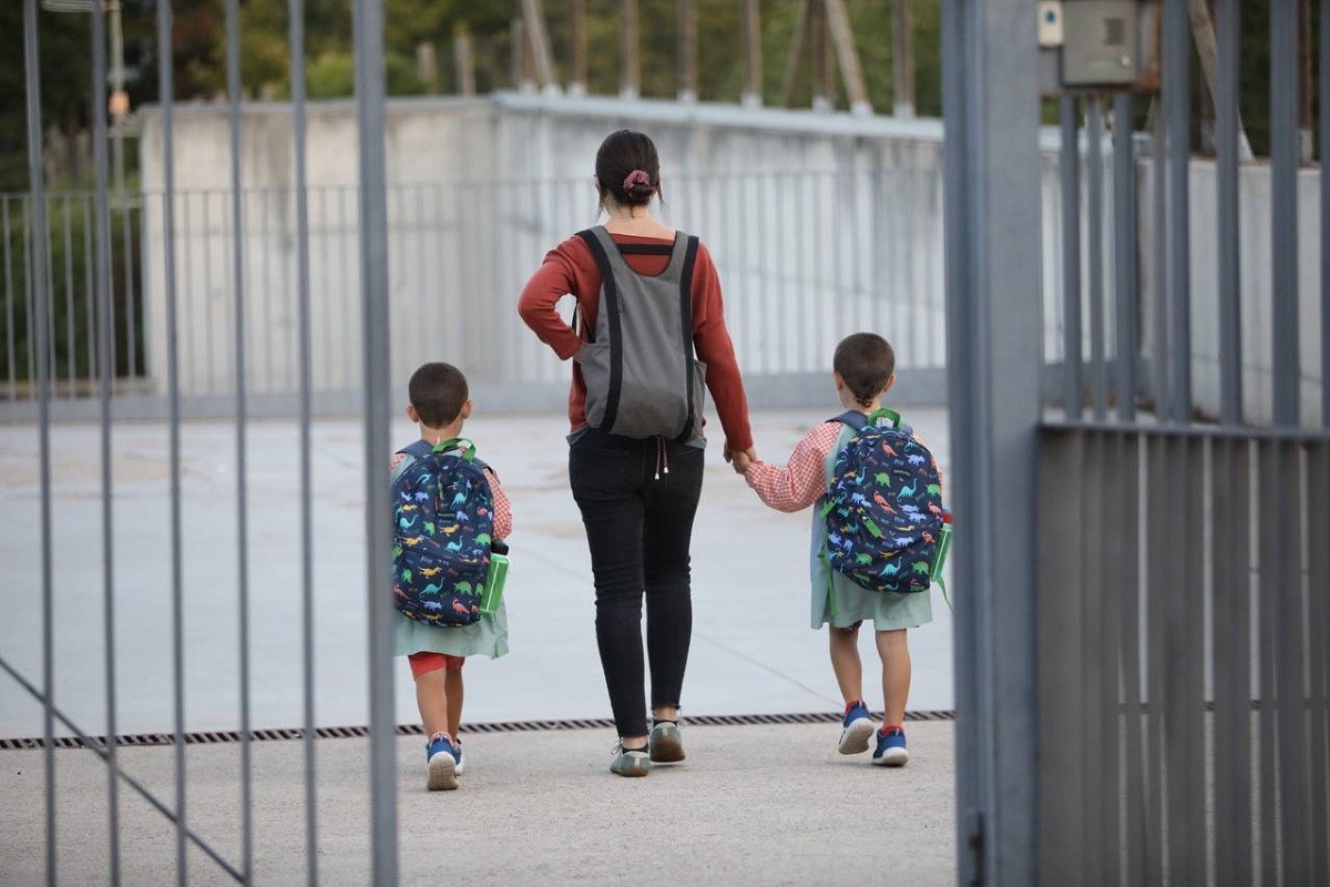 Dos nens acompanyats de la seva mare en el primer dia d'escola