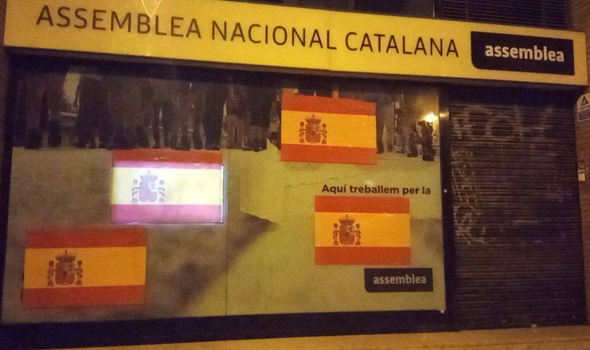 La façana de la seu de l'ANC amb banderes espanyoles