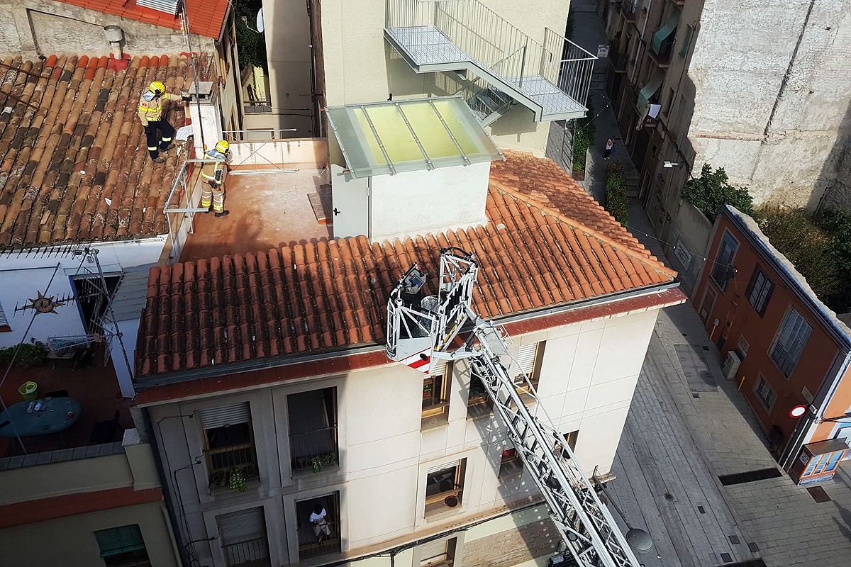 Bombers a la teulada de l'edifici adjacent per intentar entrar a l'habitatge