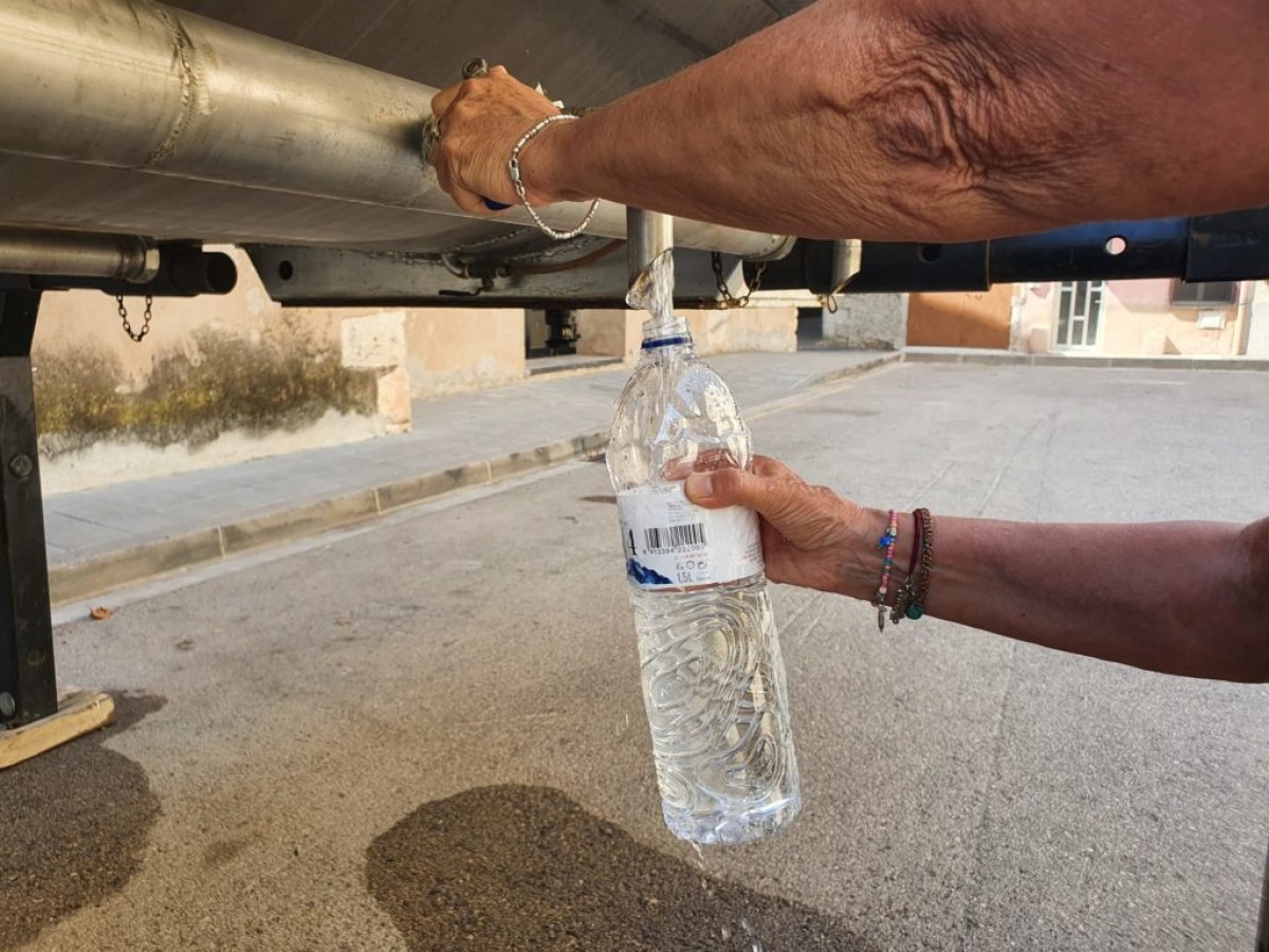 Un home retirant aigua del camió cisterna que fins ara abasteix la població d’aigua potable. 