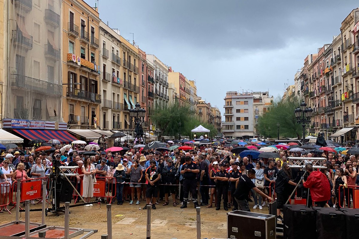 Tarragonins esperant a la plaça de la Font a què se celebrés la diada castellera de Santa Tecla, amb els paraigües oberts.