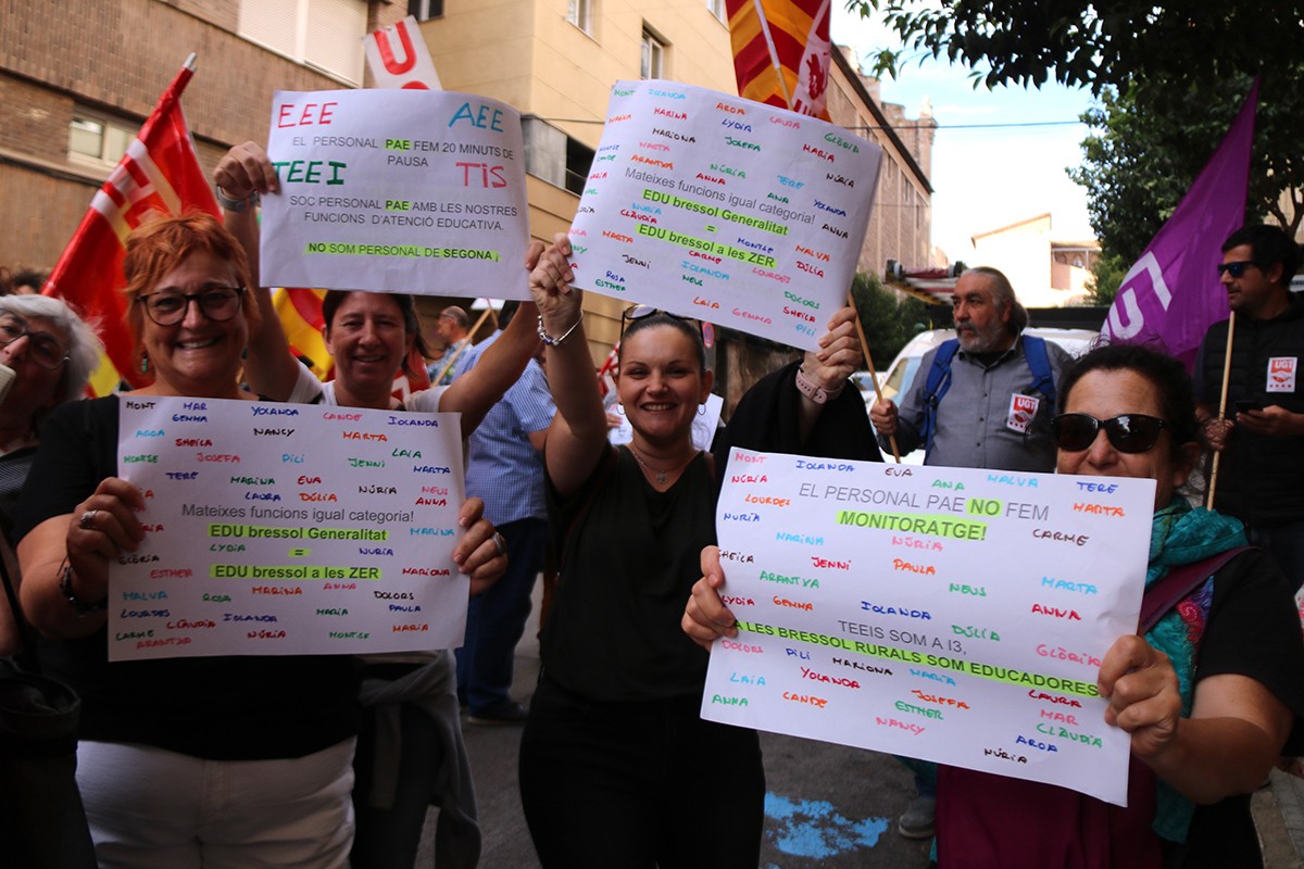 Manifestants lluint pancartes reivindicatives en la protesta feta per reclamar millores laborals del Personal d'Atenció Educativa (PAE) a Tarragona.
