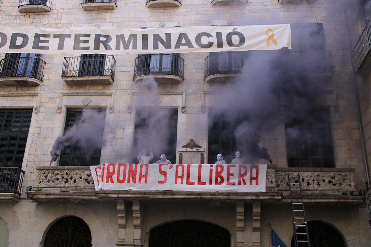 Manifestants vestits de blanc al balcó de l'Ajuntament de Girona, durant l'alliberament simbòlic de la ciutat.