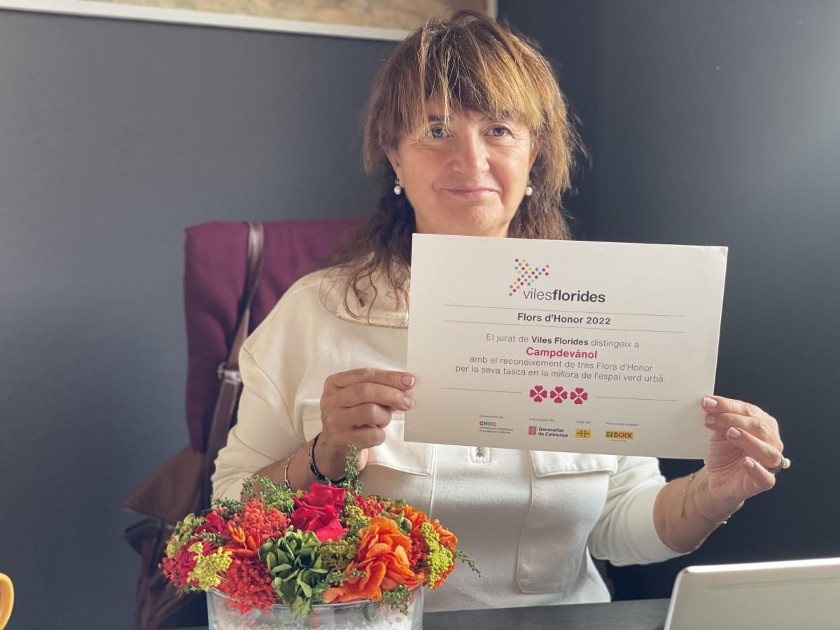 L'alcaldessa de Campdevànol amb el títol que acredita les tres flors