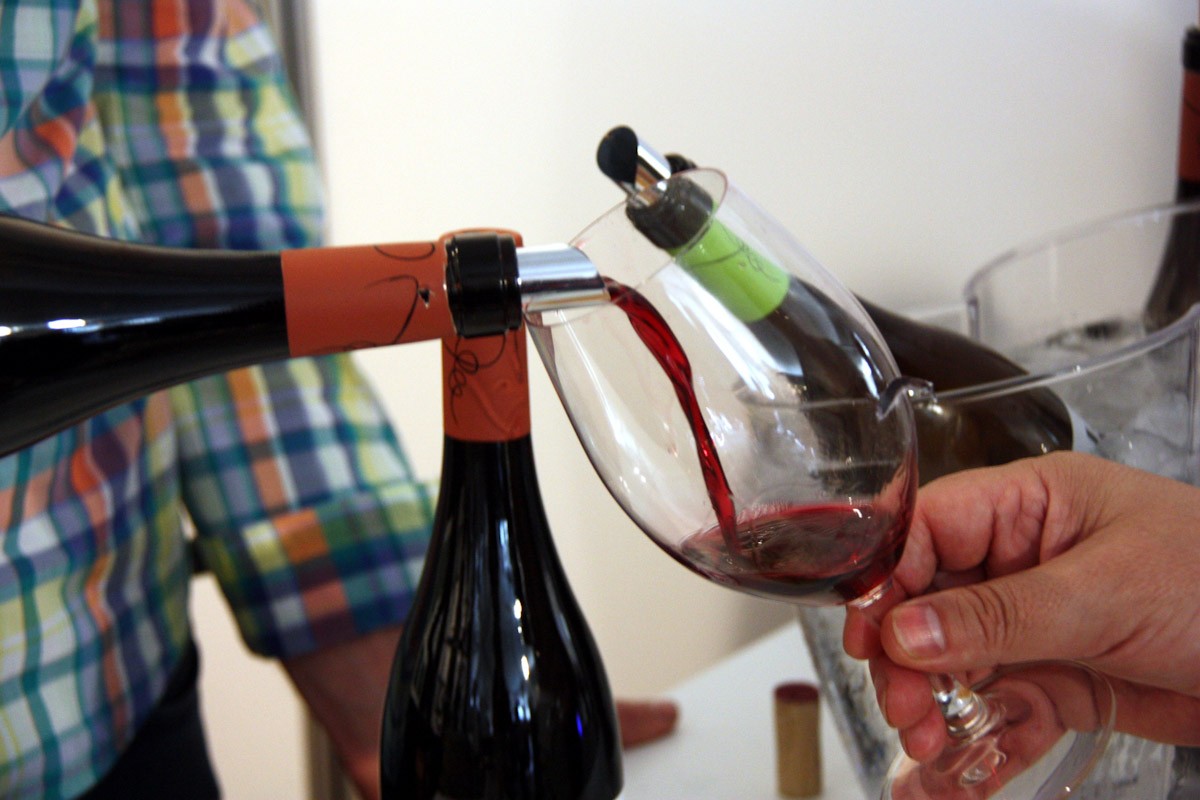 Primer pla d'una ampolla de vi servir vi negre de la DO Terra Alta a la fira del vi de Gandesa. 