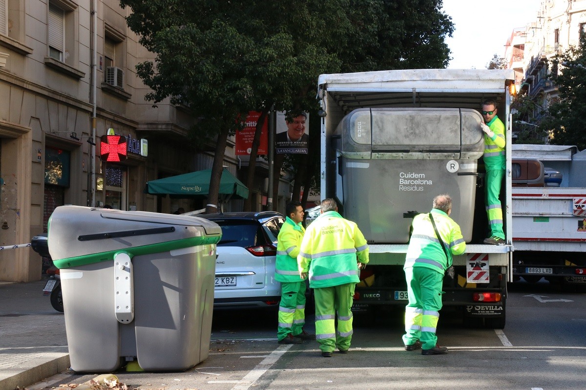 Els serveis de neteja de l'Ajuntament de Barcelona retirant el contenidor gris on s'ha localitzat el cos