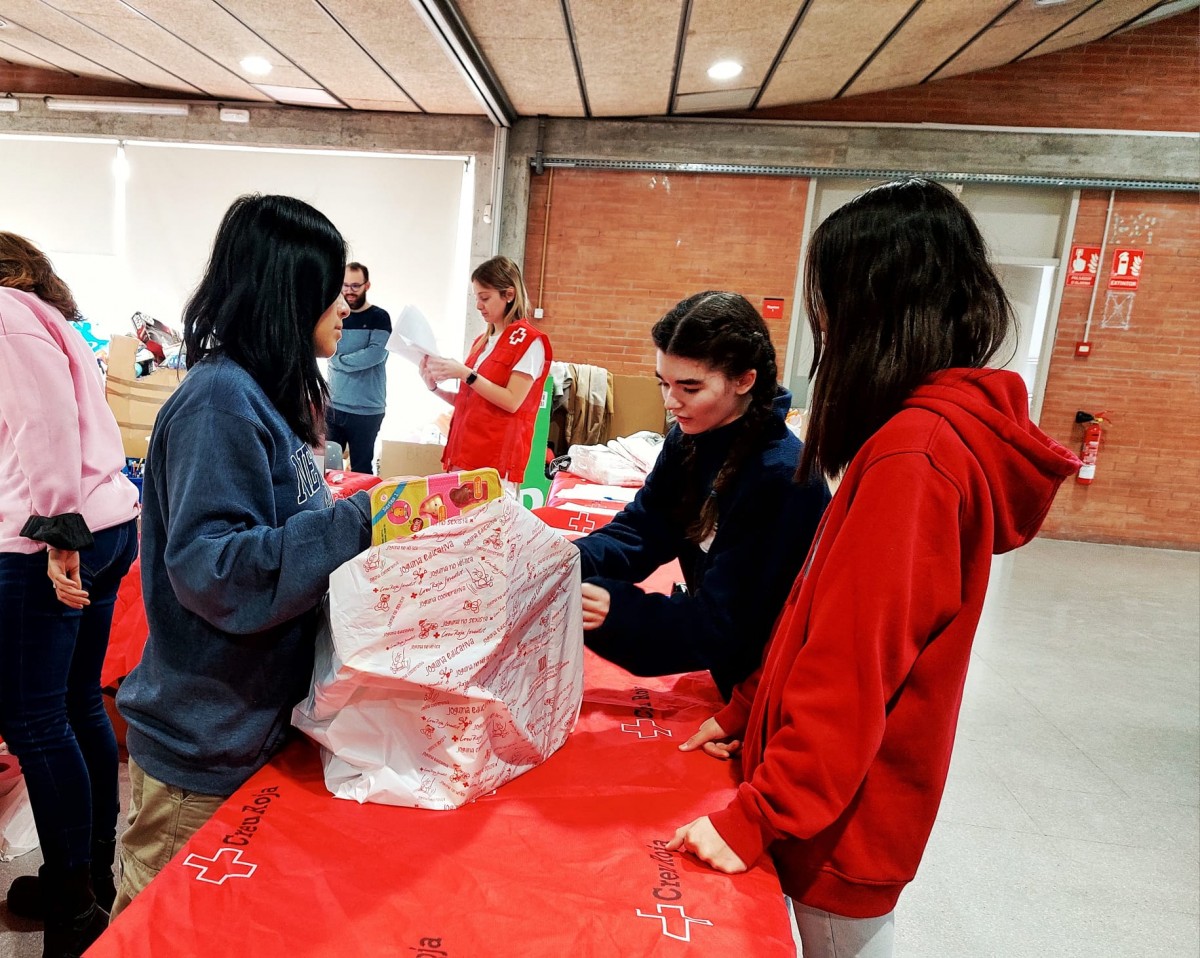 Els alumnes de l'escola El Cim Terrassa ajudant a preparar els lots de joguines de la Creu Roja