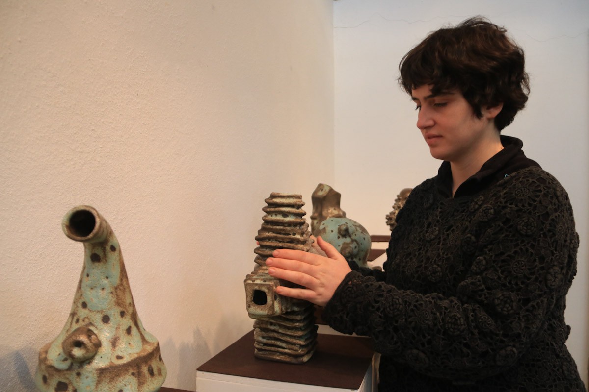 La ceramista Natàlia Gual acariciant una de les seves obres exposades al Raval de l'Art de Roquetes 