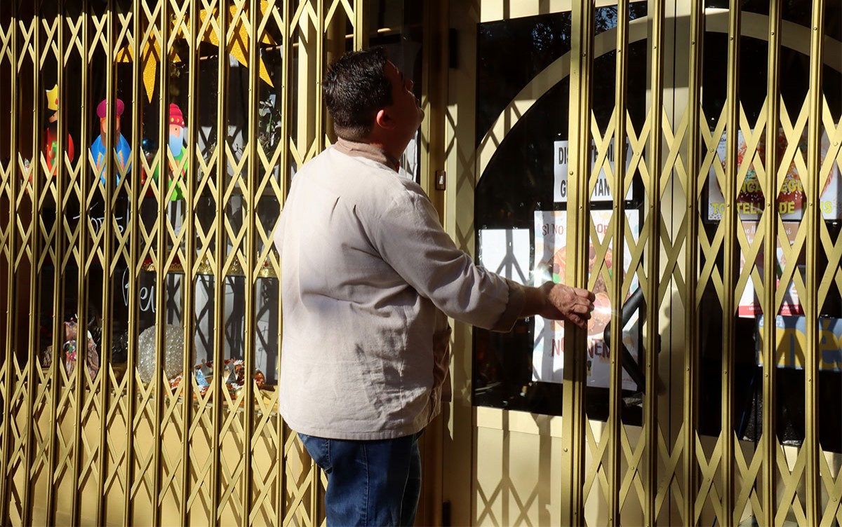 Ramon de la Fuente, tancant la porta del seu negoci durant l'aturada energètica.