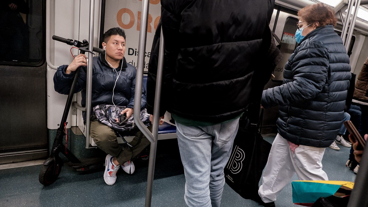 Un usuari de patinet elèctric a l'interior del metro de Barcelona