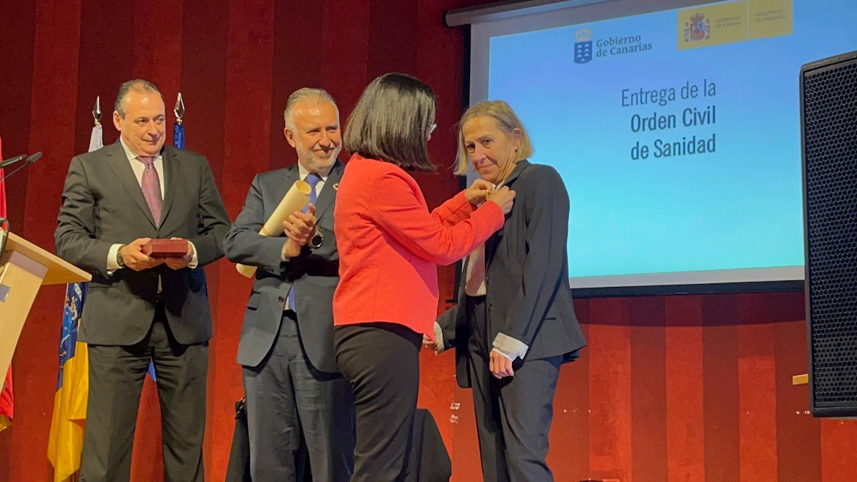 Teresa Cotonat (dreta) rebent el premi de mans de la ministra de Sanitat, Carolina Darias