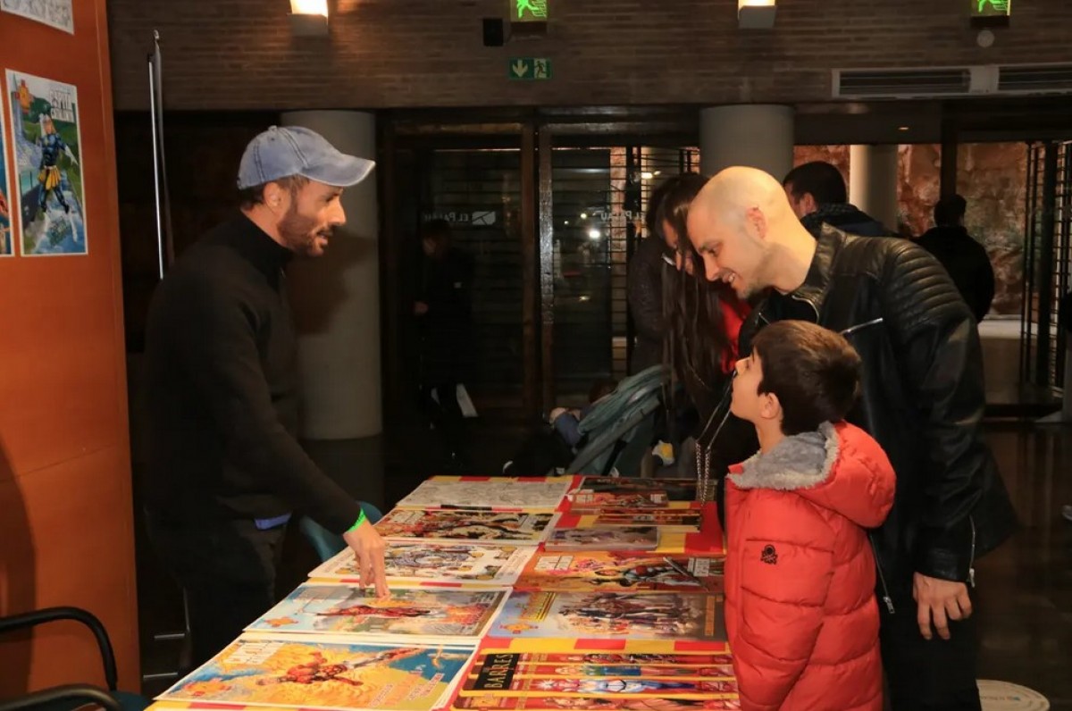 Una família observa còmics en un dels estands de la sisena edició de l'Starraco Unlimited a Tarragona