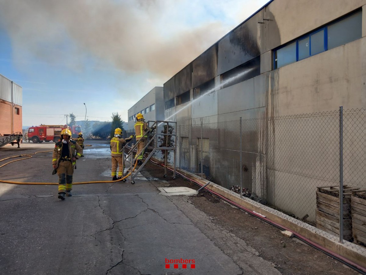 Els Bombers treballant en l'incendi d'una nau industrial a Cervera