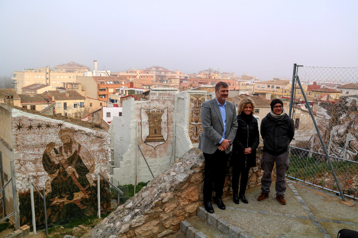 El regidor de Turisme de Tortosa, Sisco Pepió, l'alcaldessa de Tortosa, Meritxell Roigé, i l'artista Roc Blackbloc davant d'alguns dels nous murals d'art urbà i històric del barri de Sant Jaume  