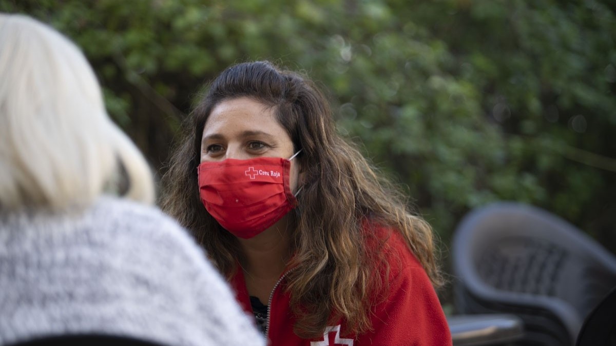 Imatge d'una voluntària de Creu Roja Tarragona atenent una dona.