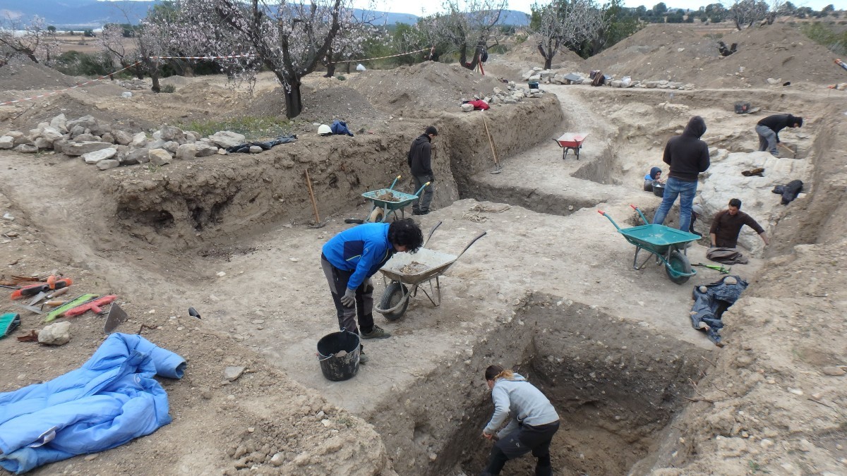 Membres de l'equip excavant dins de la gran depressió localitzada en el turó on s'ubica el jaciment.