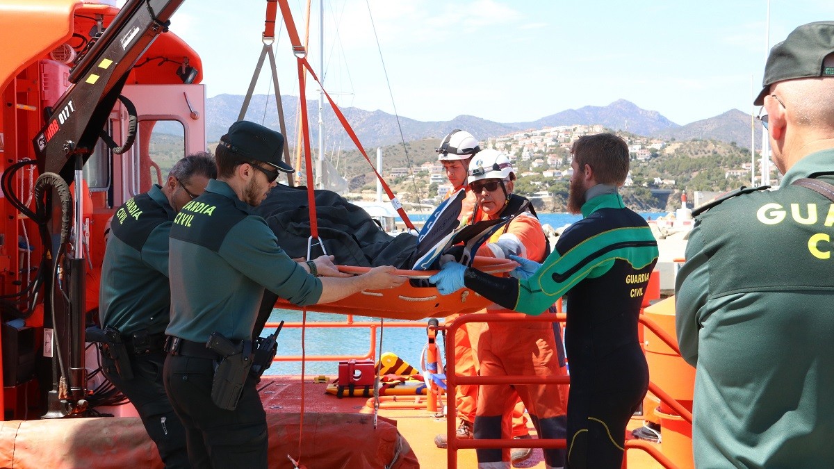 Efectius de la Guàrdia Civil i de Salvament Marítim baixant el submarinista mort a Cadaqués