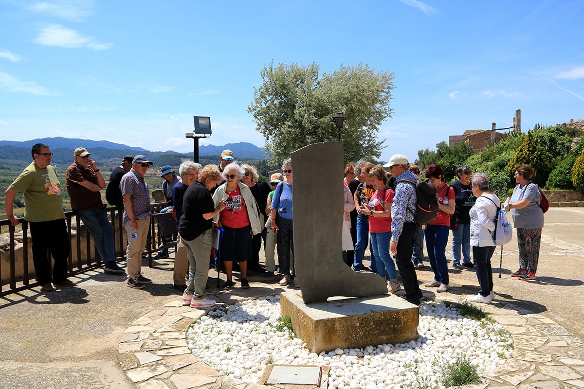 Participants en la visita guiada al Poble Vell de Corbera d'Ebre davant La bota, de Brossa.