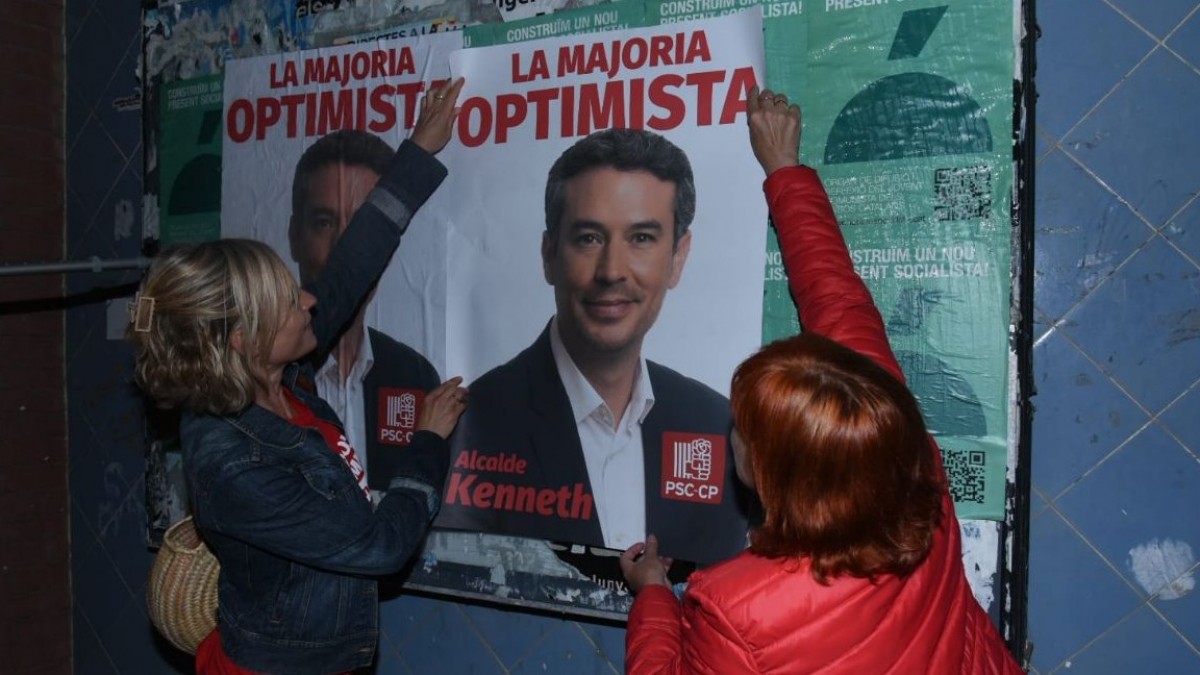 Militants socialistes enganxen un cartell de Kenneth Martínez al Vendrell.