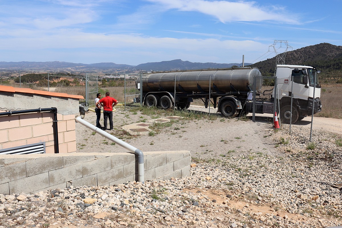 Dos treballdors omplint un dels dipòsits d'aigua de l'Espluga de Francolí amb camions cisterna.