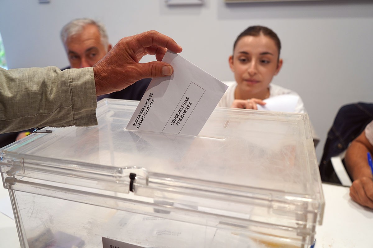Imatge d'un votant dipositant la papereta a l'urna este diumenge.