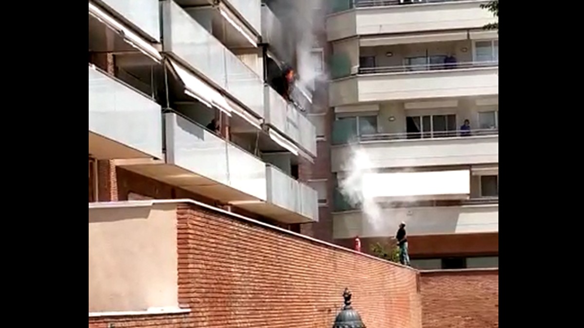 Un home intenta extingir les flames des del carrer