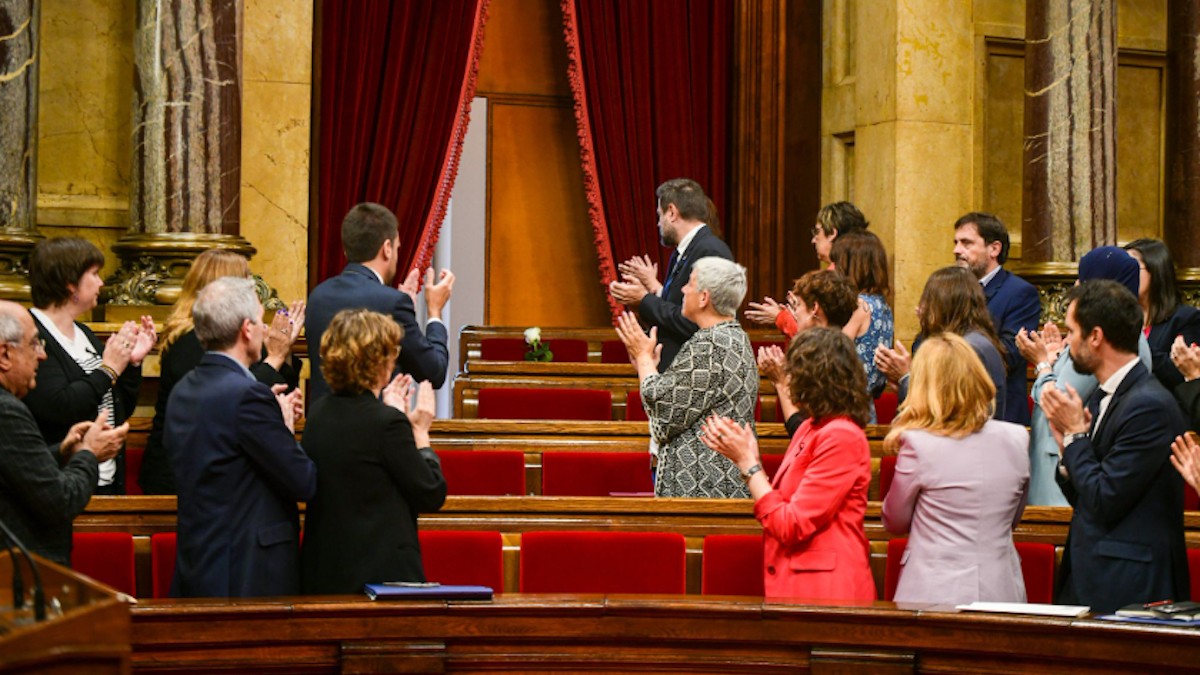 Els diputats aplaudint en record de Flores, amb una rosa blanca ocupant el seu escó
