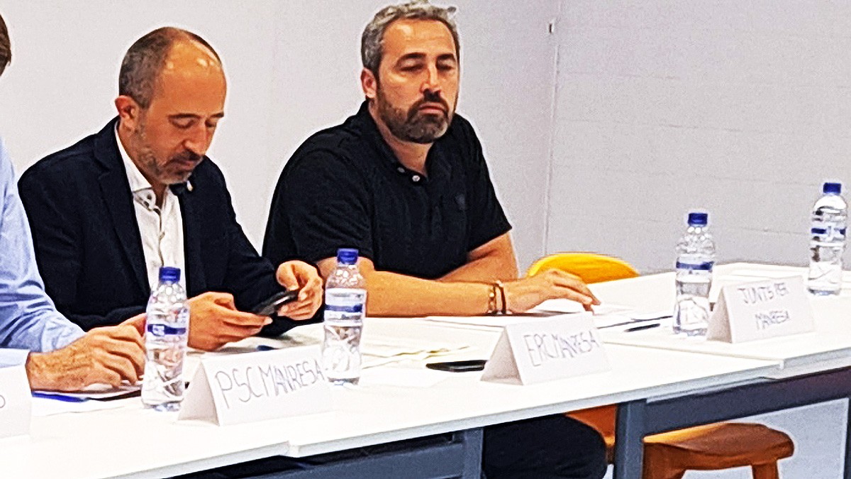 Marc Aloy i Ramon Bacardit, de costat sense mirar-se, en un debat de la campanya