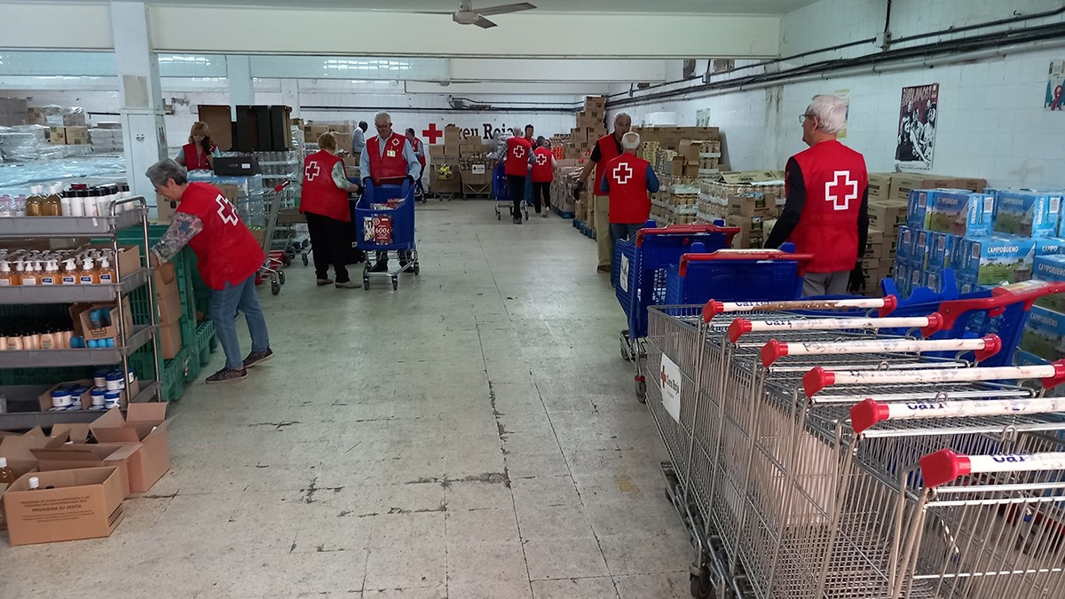 Diversos voluntaris de Creu Roja empaquetant productes.
