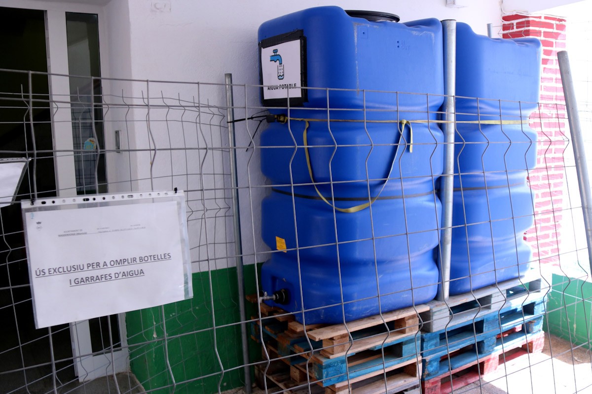Dipòsits provisionals d'aigua potable instal·lats al porxo de l'Ajuntament de Masdenverge per donar servei al veïnat