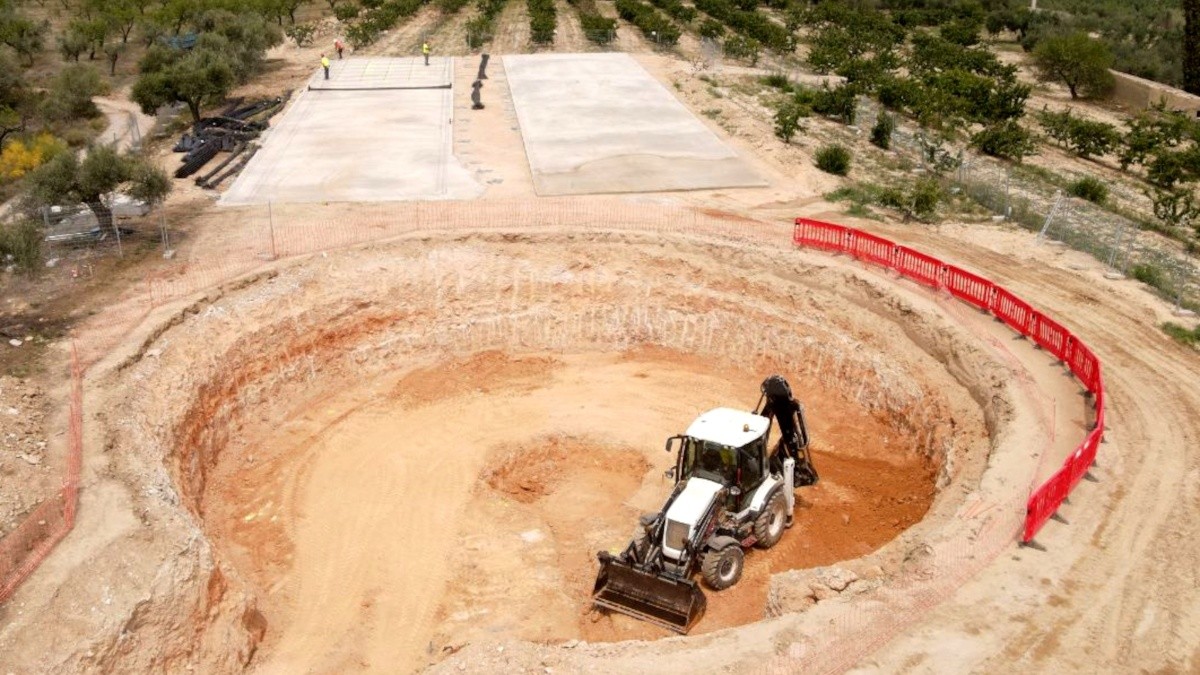 Una màquina fent moviments de terra per iniciar la construcció d'una nova depuradora a Tivissa.