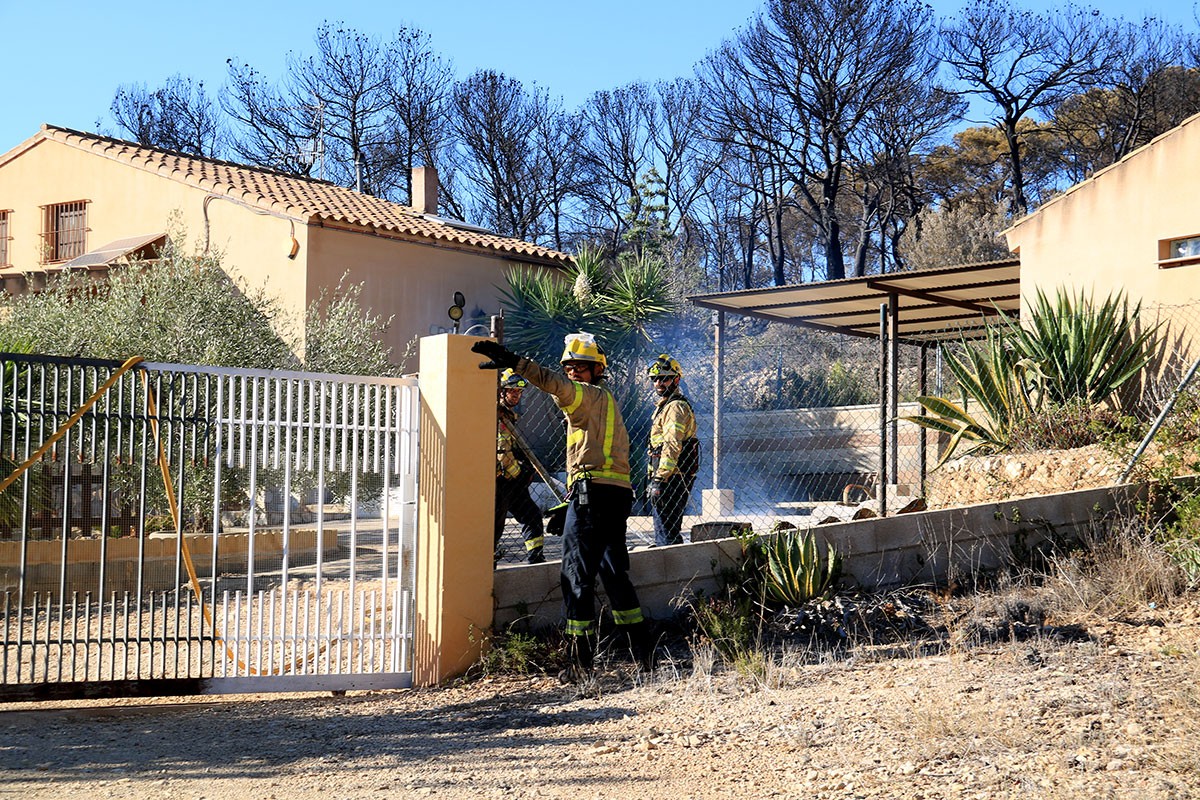 Els bombers sufocant les flames a l'interior d'una parcel·la privada.