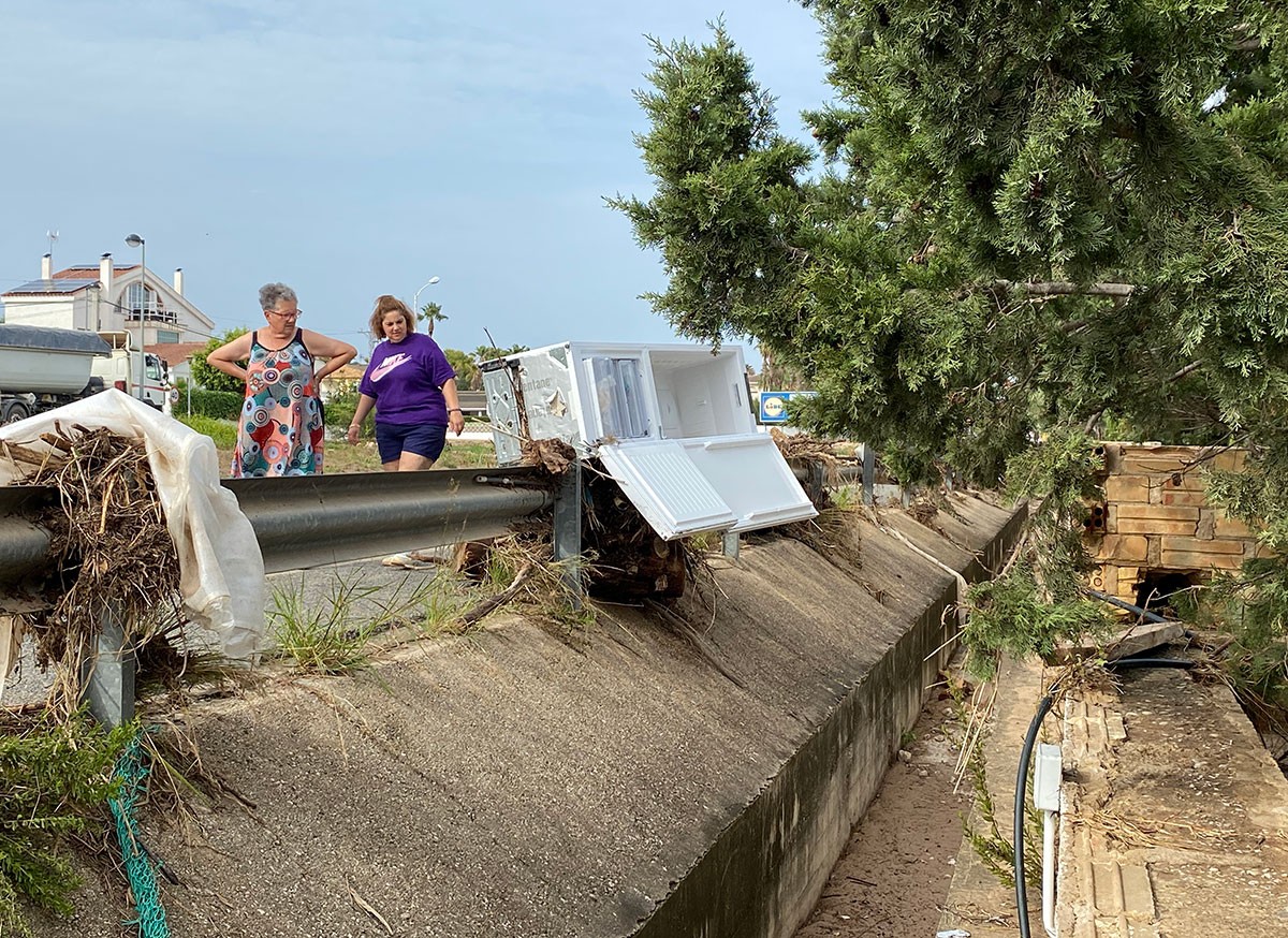 Dos veïnes observant els danys dels aiguats de diumenge a Alcanar platja.