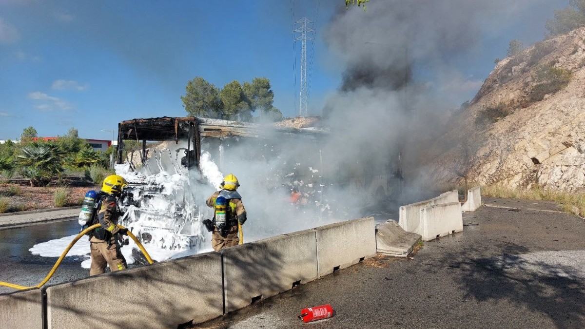 Imatge de l'autobús cremat a la C-51, a la rotonda d'accés a l'Hospital del Vendrell.