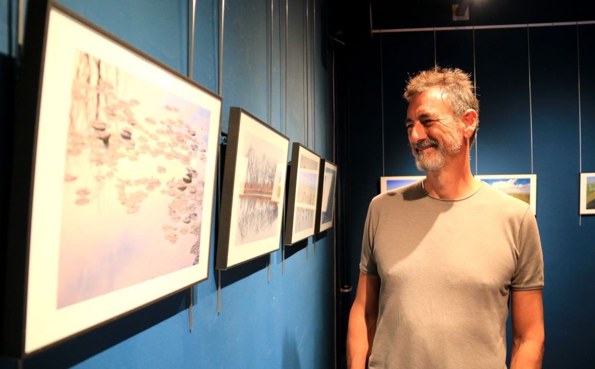 Mariano Cebolla mira somrient les fotografies del cicle Mirades del COAC  