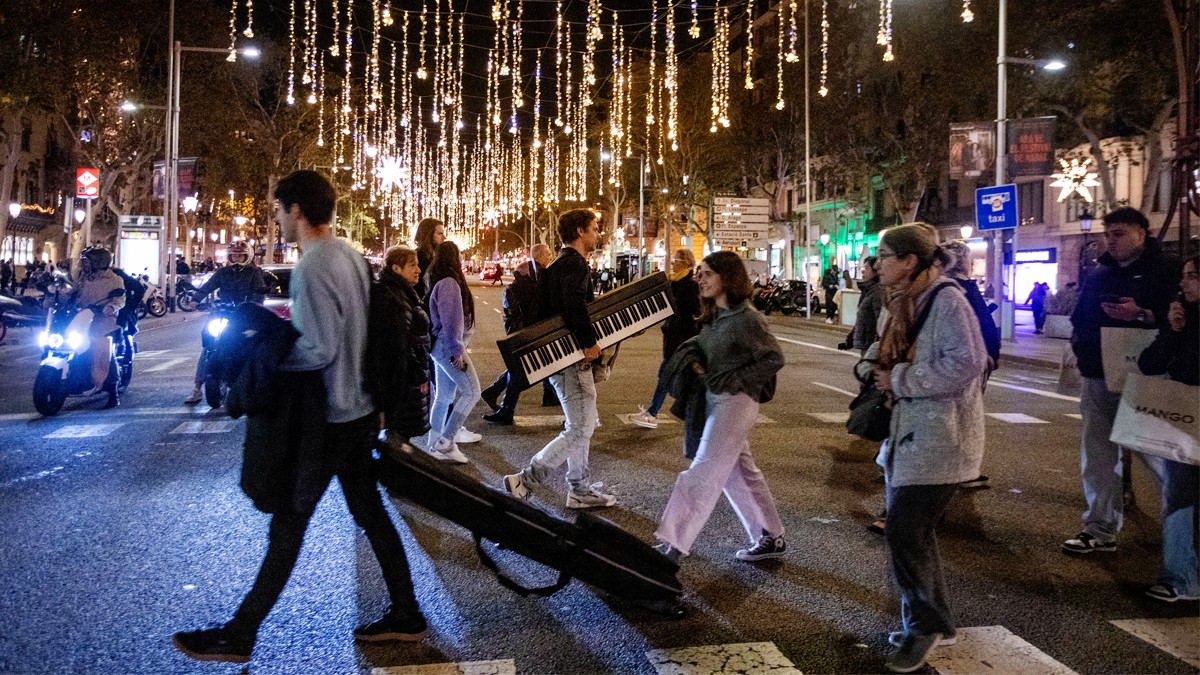 Moltes persones envaiexen el passeig de Gràcia per fer-se la foto amb l'enllumenat.