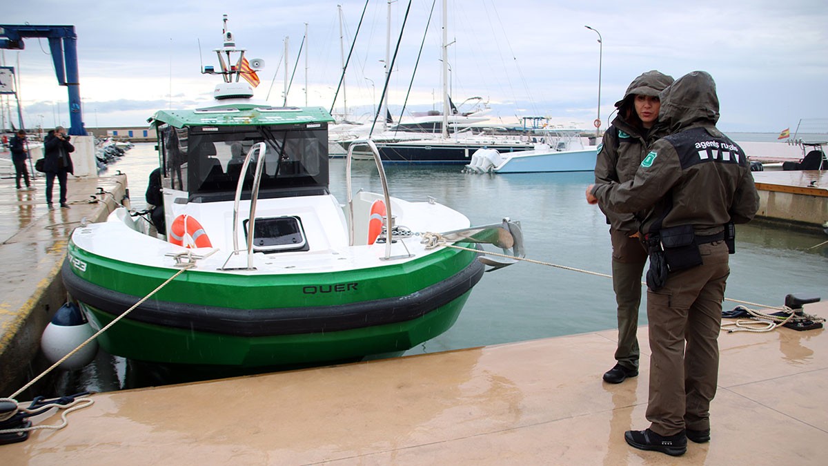 Dos agents rurals davant la nova embarcació del cos.