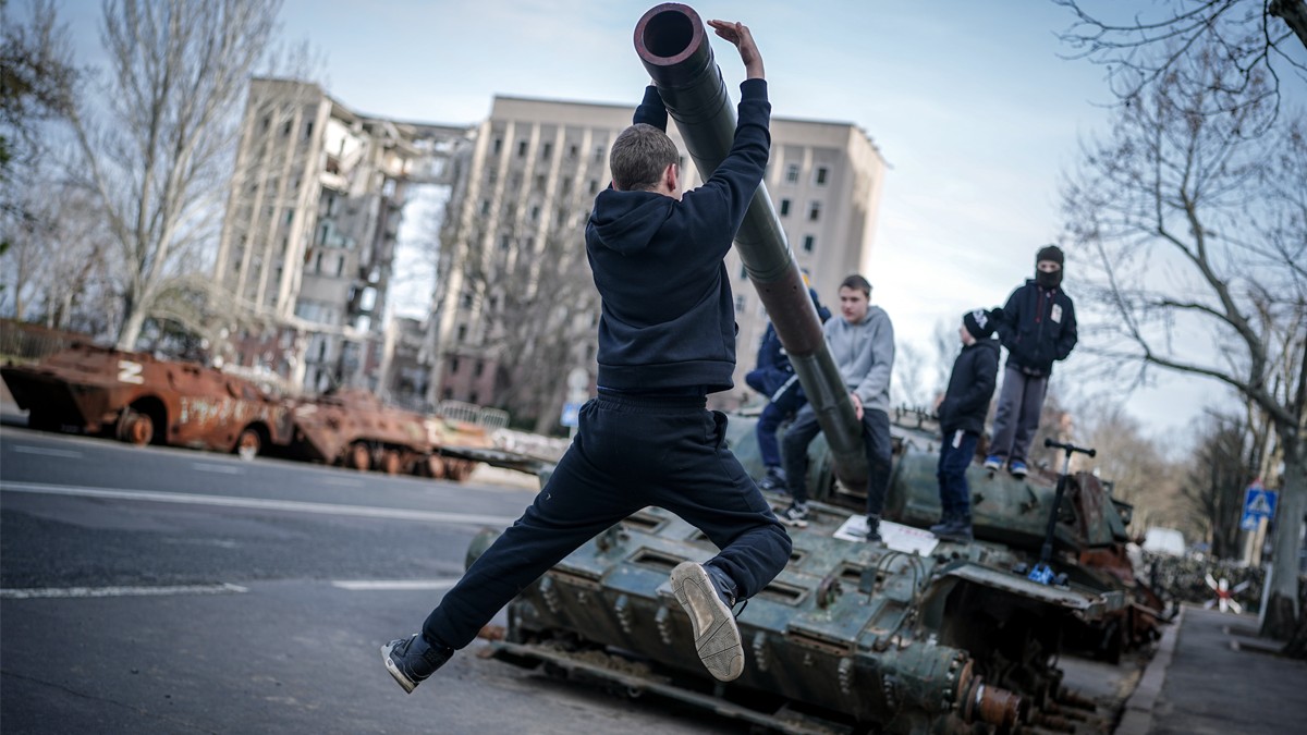 Nens juguen en un tanc rus destruït, davant de l'antiga seu de l'administració regional de l'oblast de Mykolaiv