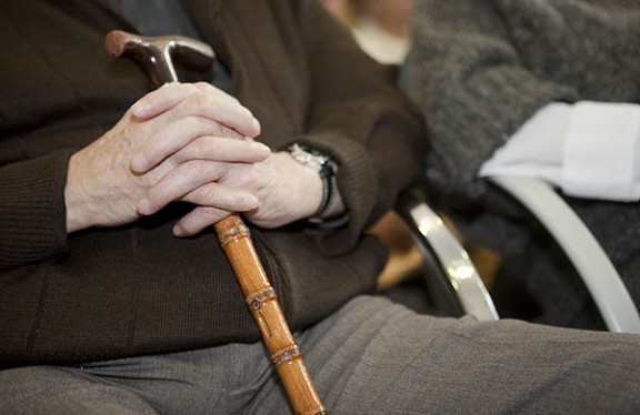Una persona d'edat avançada subjecta un bastó.