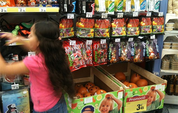 Una nena a la secció de llaminadures d'un supermercat